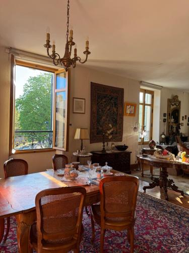 a dining room with a large wooden table and chairs at Lorcival in Savennières