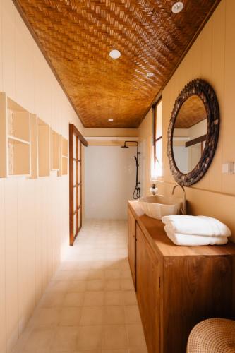 a bathroom with a sink and a mirror at Fare Teiti Beach Bungalow in Haapiti