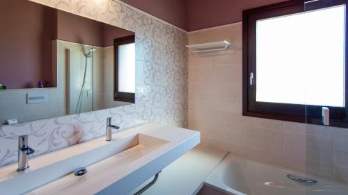 a bathroom with a sink and a mirror and a tub at LES FEIXES LLARGUES - max 18 pax in Bolvir