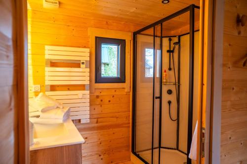 a bathroom with a shower in a wooden room at Gîte de charme Ò Chalet in Camors