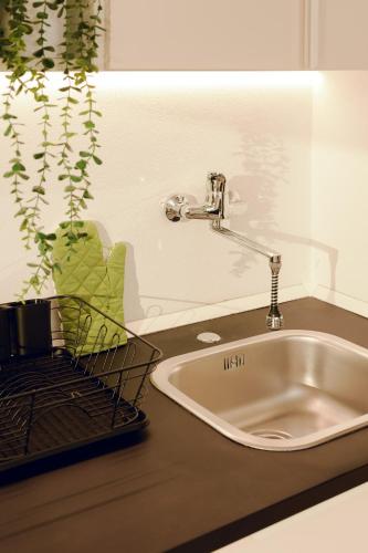 a kitchen counter with a sink and a plant at SHARED SWIMMING POOL, House relax Lu Bagnu in Castelsardo