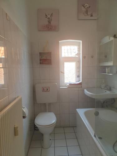 a bathroom with a toilet and a tub and a sink at Ferienhaus am DEISTER in Barsinghausen