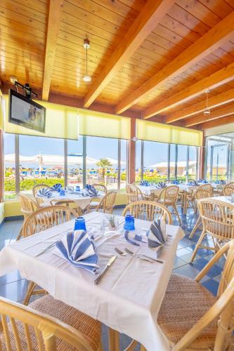 a dining room with white tables and chairs at Hotel Marina in Fano
