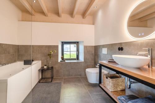 a bathroom with a sink and a tub and a toilet at Glamorous Cottage mit Kamin und Sauna in Dahlem
