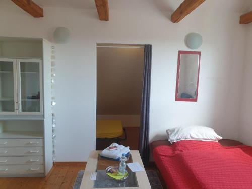 a bedroom with a red bed and a table at Ferienhaus am DEISTER in Barsinghausen
