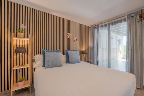 a bedroom with a large white bed with blue pillows at Flateli Montjuïc in Girona