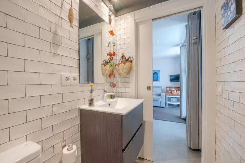 a bathroom with a sink and a toilet and a mirror at Flateli Montjuïc in Girona