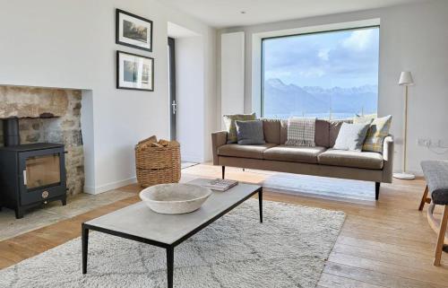 a living room with a couch and a fireplace at Taigh Druim in Elgol
