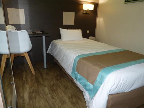 a hotel room with a bed and a desk at Hotel ARBOR - Les Hunaudieres - Le Mans Sud - Mulsanne in Mulsanne