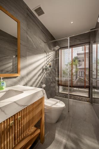 a bathroom with a toilet and a sink and a mirror at Sora Villa, Huge Swimming Pool, Private Sauna & Elevator Access in Danang