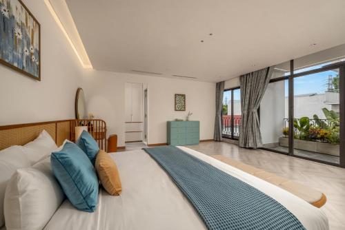a bedroom with a large bed with blue pillows at Sora Villa, Huge Swimming Pool, Private Sauna & Elevator Access in Danang