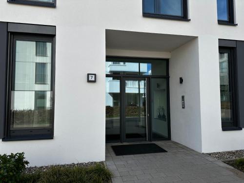 an entrance to a white building with glass doors at FeWo RoSi SN in Schwerin