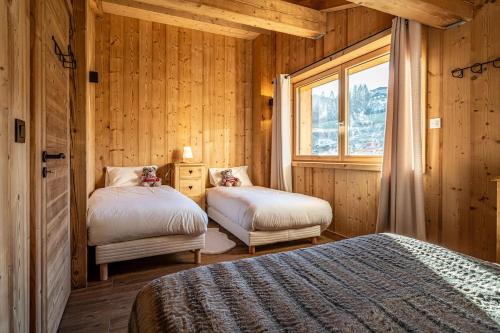 a bedroom with two beds and a window at Chalet Cocoon in Combloux