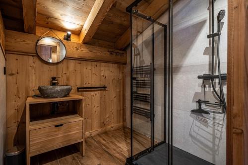 a bathroom with a glass shower and a sink at Chalet Cocoon in Combloux