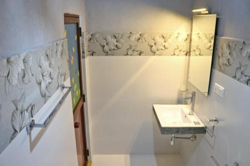 ein Bad mit einem Waschbecken und einem Spiegel in der Unterkunft Sweden Inn Guesthouse in Hikkaduwa