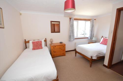 a bedroom with two beds and a window at Kingfisher Lodge in Wroxham