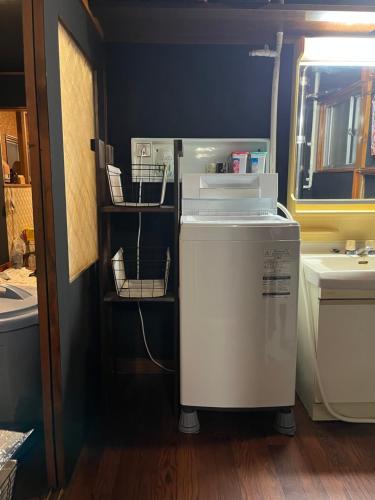a kitchen with a washer and dryer in a room at Lodging House NAO in Aomori