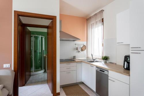 a small kitchen with white cabinets and a sink at Calm House in Desenzano del Garda