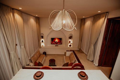 a living room with a fireplace and a chandelier at Nook Villas in Bagamoyo