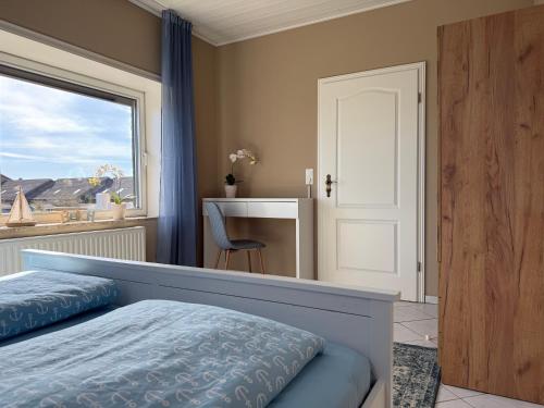 a bedroom with a bed and a window and a desk at Diekbude Nr 53 in Friedrichskoog