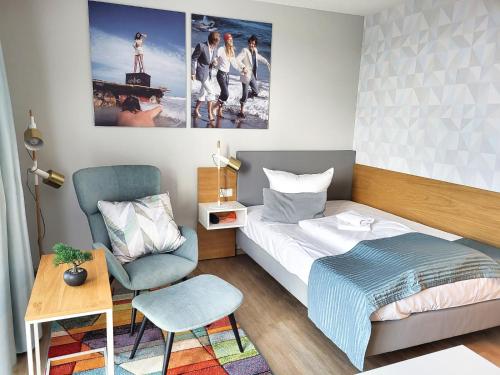 a small bedroom with a bed and a chair at NINO-Boardinghouse 16 in Nordhorn