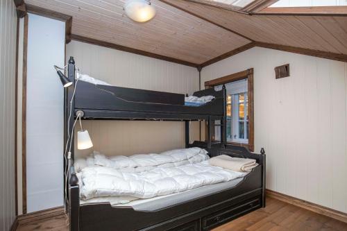 a bedroom with a black bed with white sheets at Rauland, Listaullii in Torvetjørn
