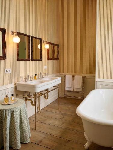 a bathroom with two sinks and a bath tub at Château du Tertre in Arsac