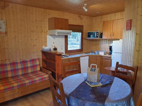 a kitchen with a table and a table and chairs at Chalet confort in Saint-Rémy
