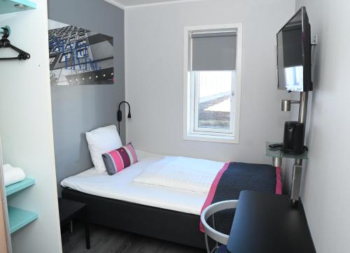 a small room with a bed and a tv at Cabinn Aalborg in Aalborg