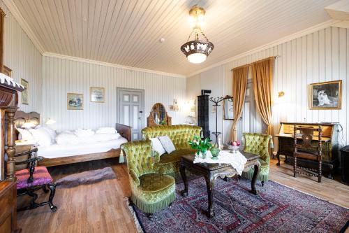 a living room with a bed and a table and chairs at Negarden 1897 in Åsnes