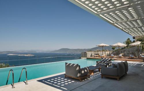 a swimming pool with chairs and a table at WAM by Karma in Bodrum City