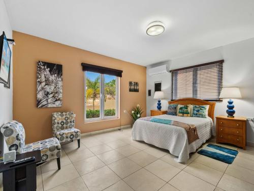a bedroom with a bed and a desk and a window at Villa Savannah in Savaneta