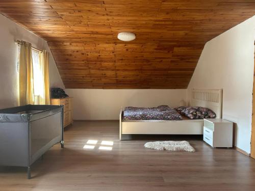 a bedroom with a bed and a wooden ceiling at Andělský sklípek in Dolní Věstonice