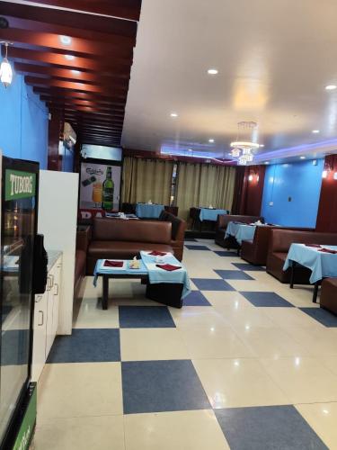 a restaurant with couches and tables in a room at Hotel Aahar chitawan in Bharatpur
