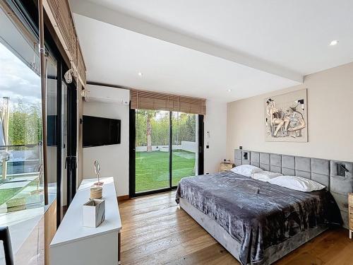 a bedroom with a large bed and a large window at Maison de prestige à Grimaud in Grimaud