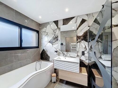 a bathroom with a tub and a sink and a bath tub at Maison de prestige à Grimaud in Grimaud