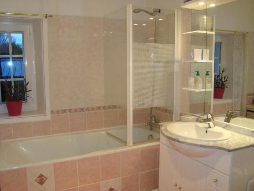 une salle de bain avec une baignoire et un lavabo dans l'établissement La Maison Claire, à Longueville
