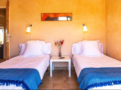 a room with two beds and a table with flowers at Finca Bassa Serra in Santanyi