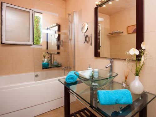 a bathroom with a glass sink and a tub at Finca Bassa Serra in Santanyi