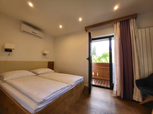 a bedroom with a bed and a large window at Penzion Tavcar in Ljubljana