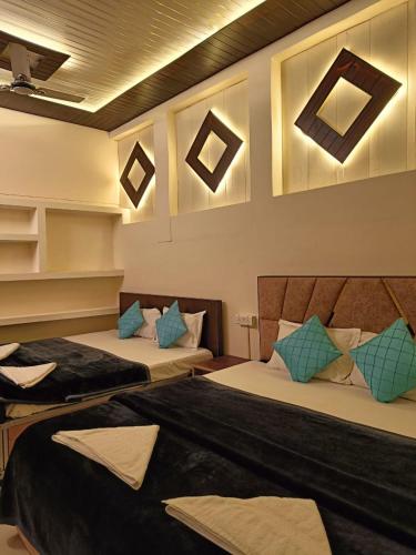 a room with two beds with blue pillows at The Mystery Hostel in Varanasi