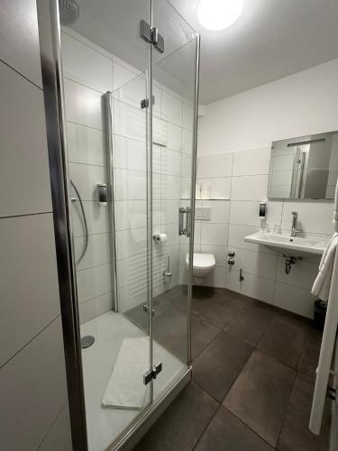 a bathroom with a glass shower and a sink at Hotel-Restaurant Dechbettener Hof in Regensburg