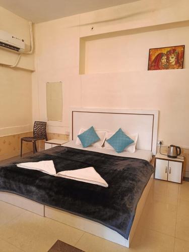 a bedroom with a large bed with blue pillows at The Mystery Hostel in Varanasi