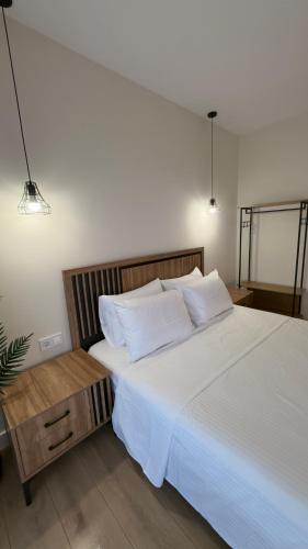 a bedroom with a large bed with white sheets and pillows at Sweet Nest in Paralia Katerinis