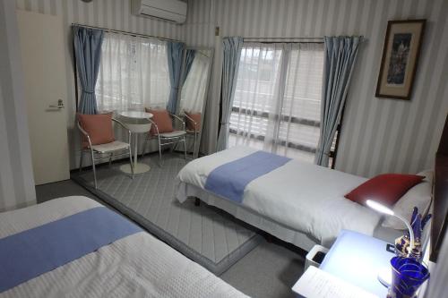 a hotel room with two beds and a mirror at KazenoKi in Kichijōji