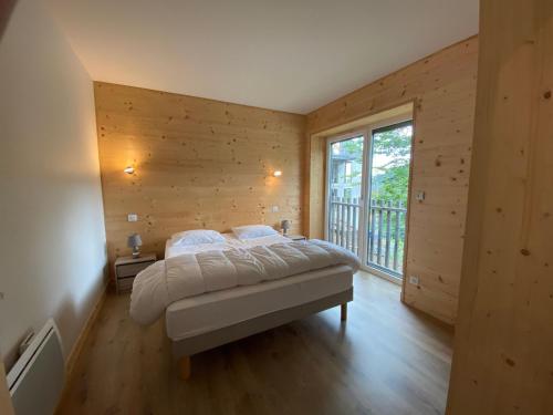 a bedroom with a bed and a large window at Les Estives R-2G in Le Lioran