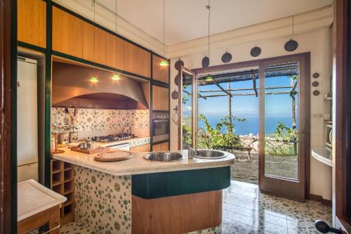 a kitchen with two sinks and a view of the ocean at GOCCE VILLAS - Sunshine Villa in Massa Lubrense