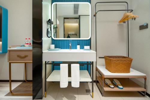 a bathroom with a sink and a mirror at Echarm Hotel Guangzhou East Railway Station South China Normal University Metro Station in Guangzhou