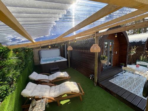 a patio with couches and a television on a deck at Go Glamping at Inverness & Loch Ness in Inverness