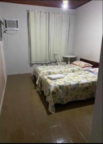 ein Schlafzimmer mit einem Bett und einem Fenster in der Unterkunft Hotel Malacarne in Teixeira de Freitas